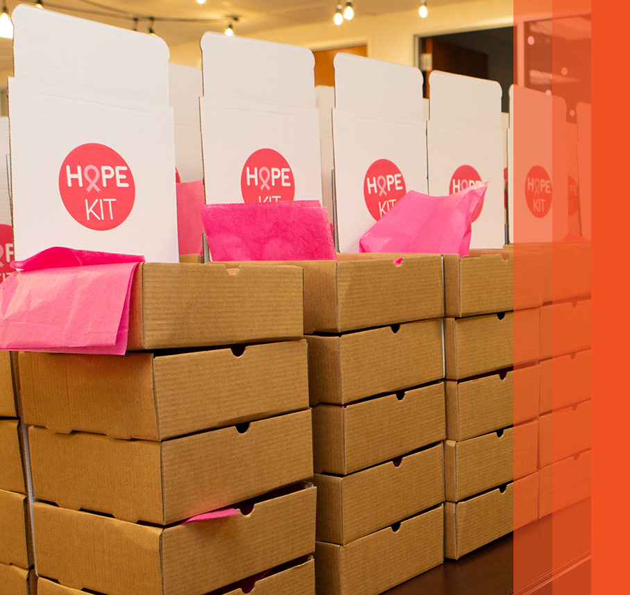 Stacks of “Hope Kit” boxes with pink tissue paper.