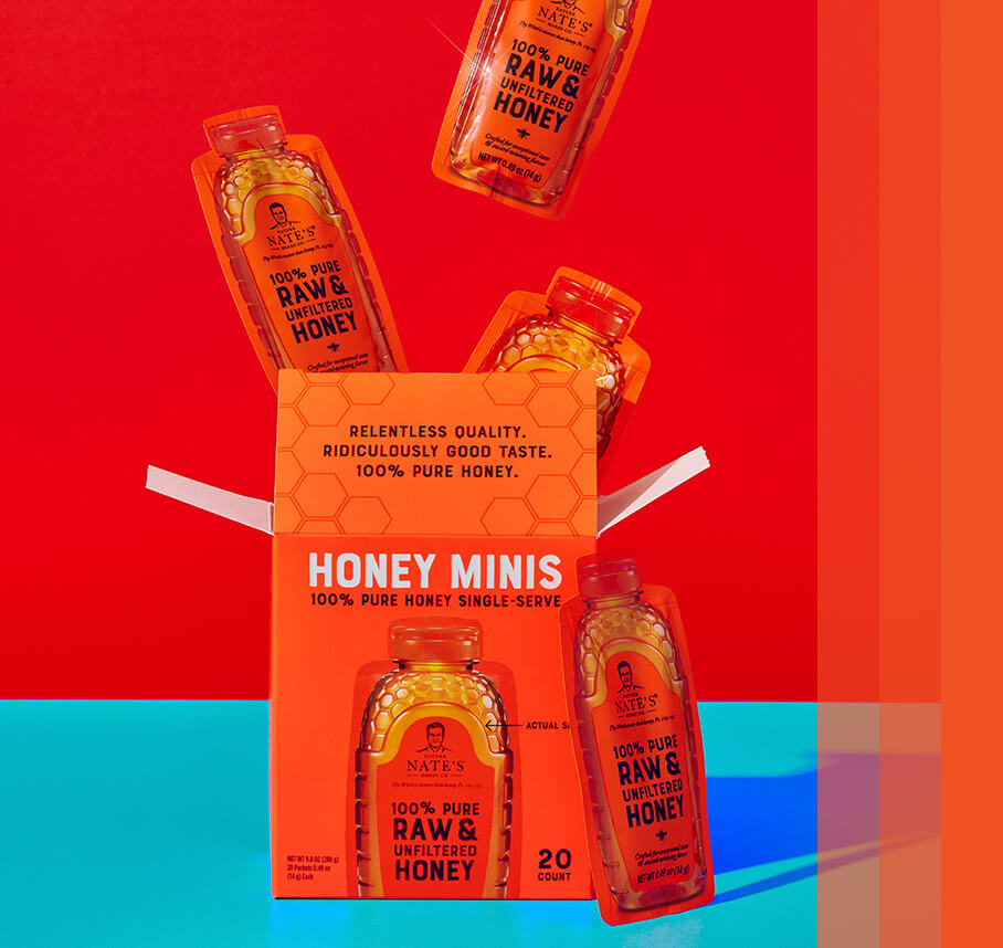 Honey minis box popping open with three honey minis ascending upwards. One honey mini leaned up against box on front right.