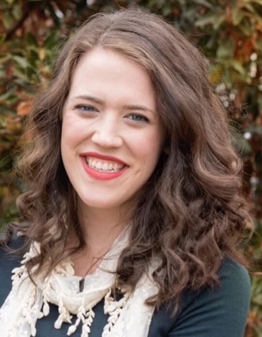 A member of Nate's people team outdoors with trees in the background.