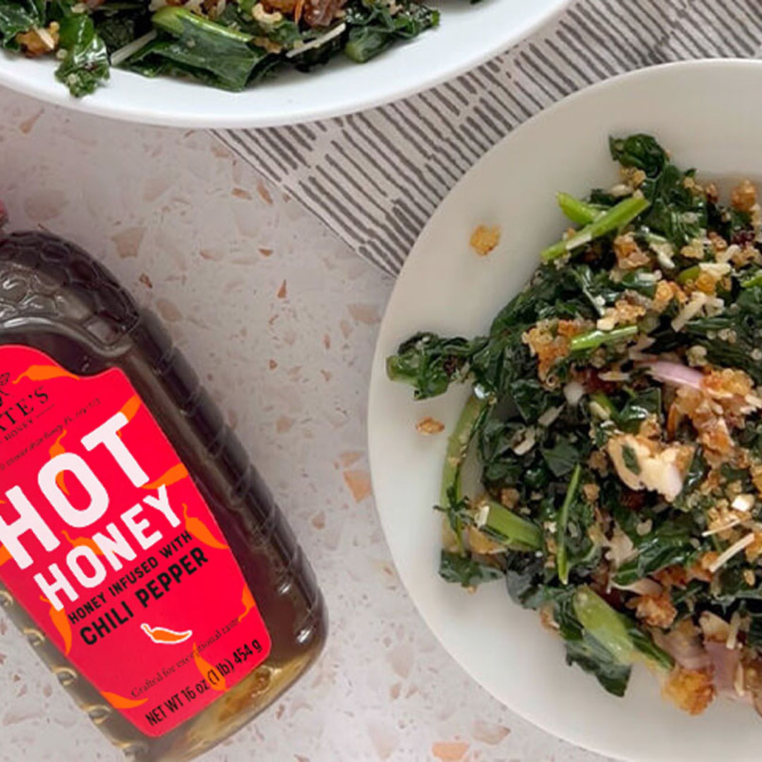 Bowl of kale and quinoa salad next to Nate's Hot Honey bottle.