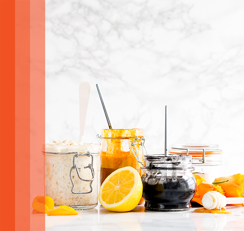 Glass jars of honey, lemon, and oats arranged on a bright kitchen counter.
