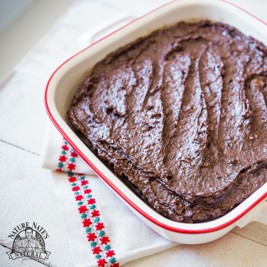 A pan of homemade brownies on a white napkin, next to a logo of Nature Nate’s Honey Co. A pan of homemade brownies on a white napkin, next to a logo of Nature Nate’s Honey Co.