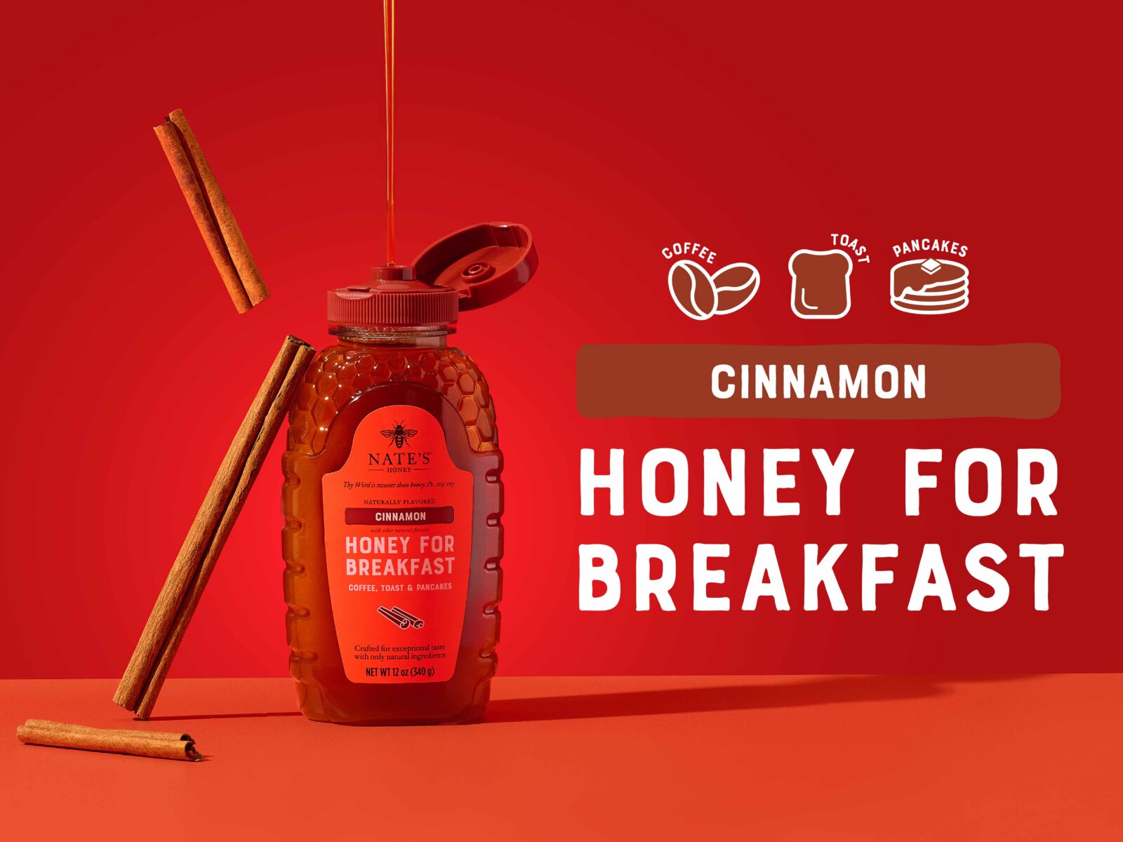 Nate’s Cinnamon Honey bottle with cinnamon sticks and honey drizzle on a red background.