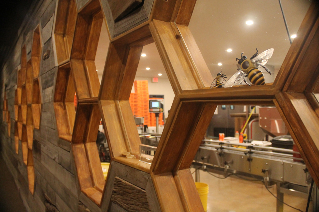  Decorative honeycomb wall with bee figure in a honey production facility.