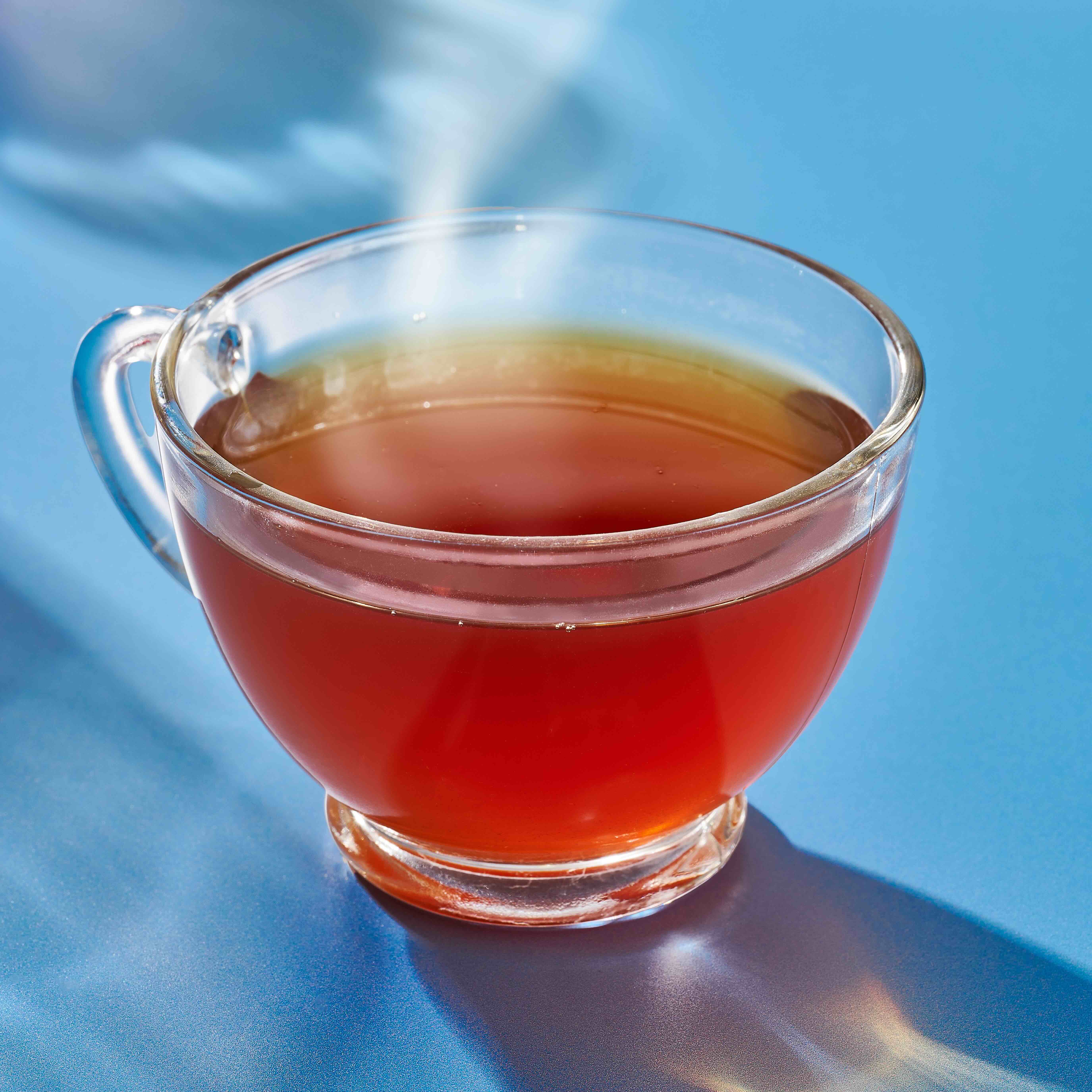 Steaming cup of tea in clear mug.