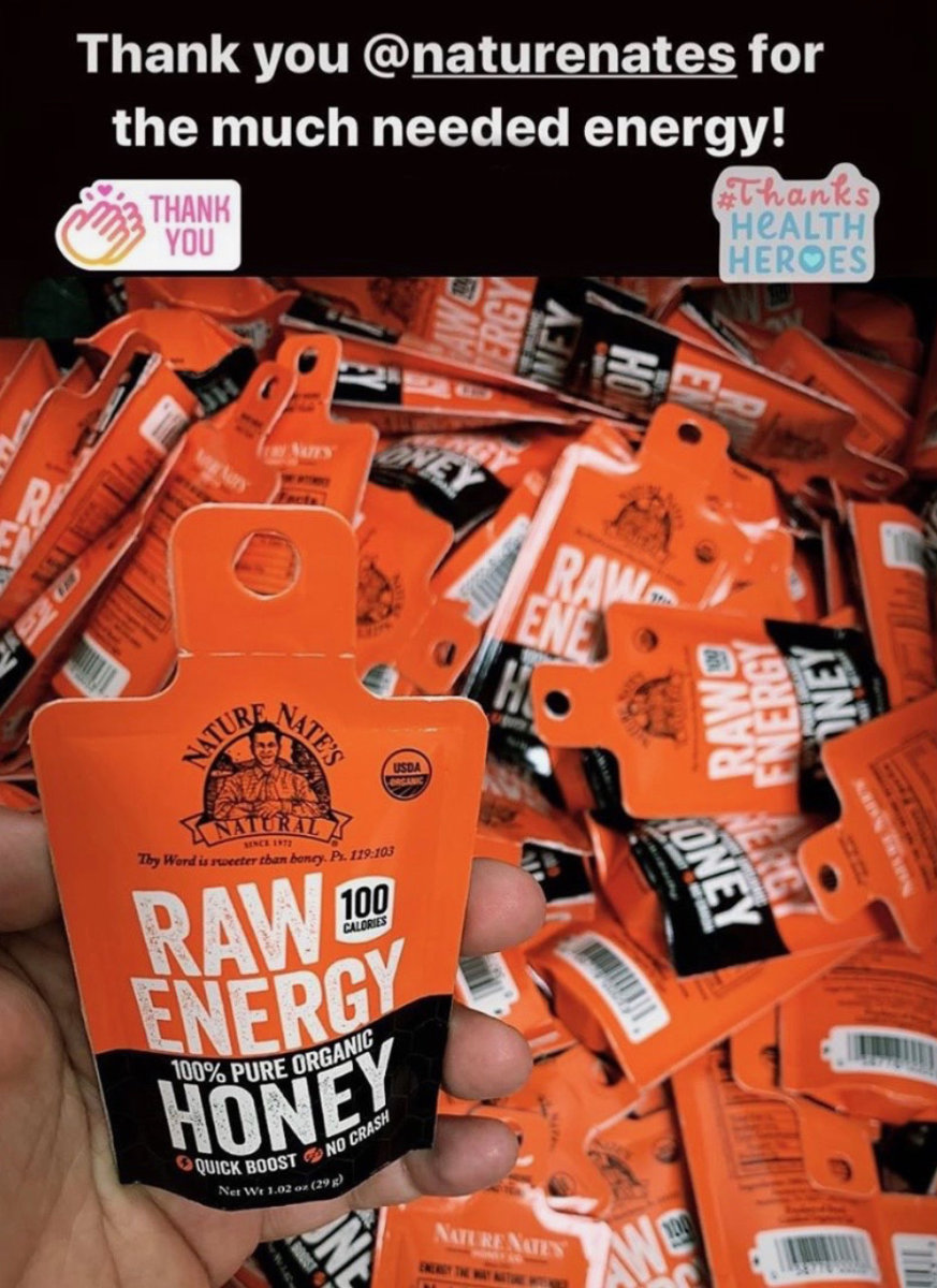 Hand holding a Nate's Raw Energy honey packet with more packets  in the background and a thank you note.