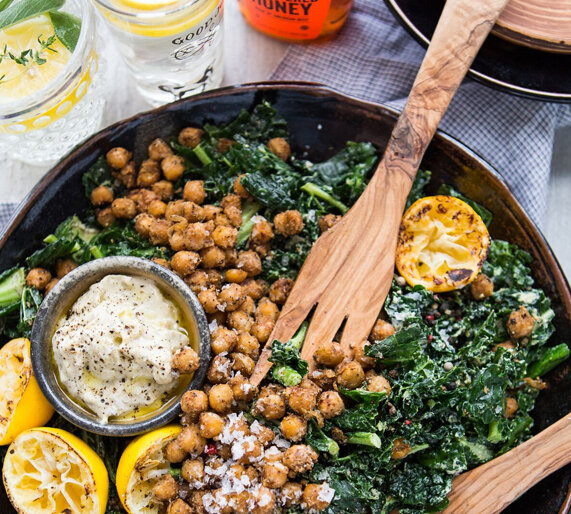 Kale and chickpea salad with tahini dressing, alongside honey and lemon water and a bottle of Nate's honey.