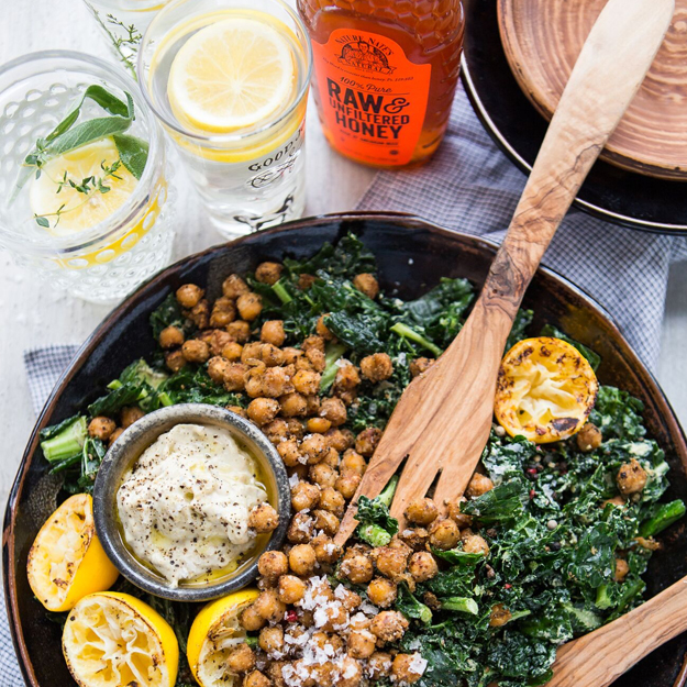 Kale and chickpea salad with tahini dressing, alongside honey and lemon water and a bottle of Nate's honey.