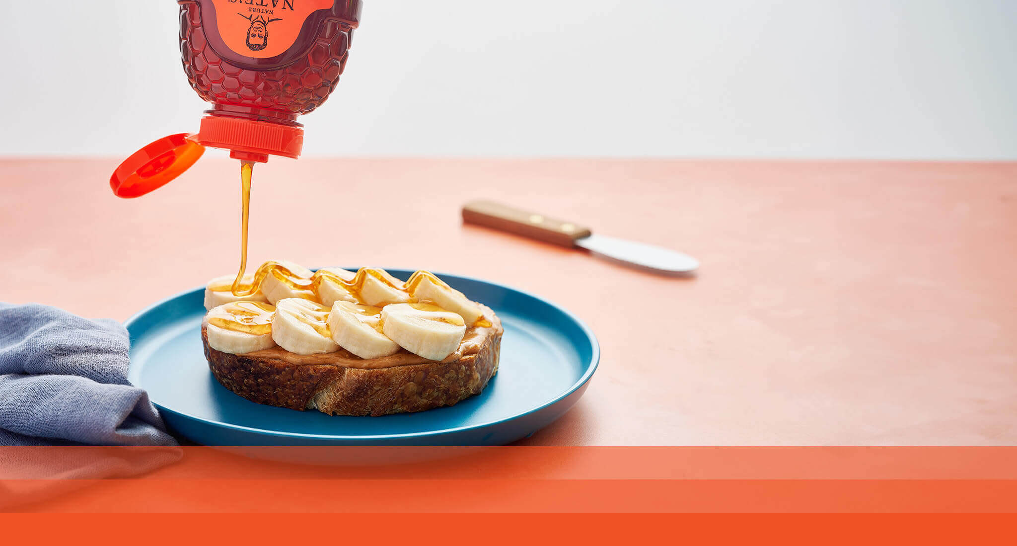 Nate’s honey being drizzled on peanut butter and banana toast.