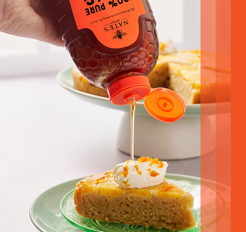 Drizzling honey on honey ginger carrot cake from a Nate’s honey bottle.