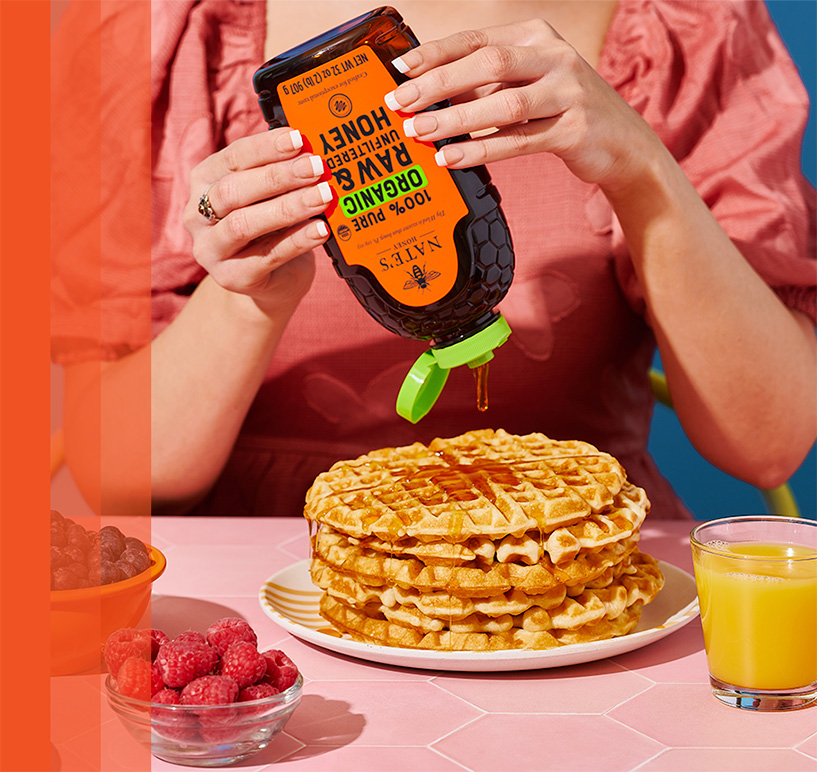 Organic honey being drizzled over waffles.