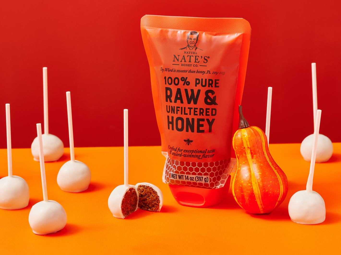 Nate’s honey pouch, pumpkin spice cake pops and a decorative squash on an orange and red background.