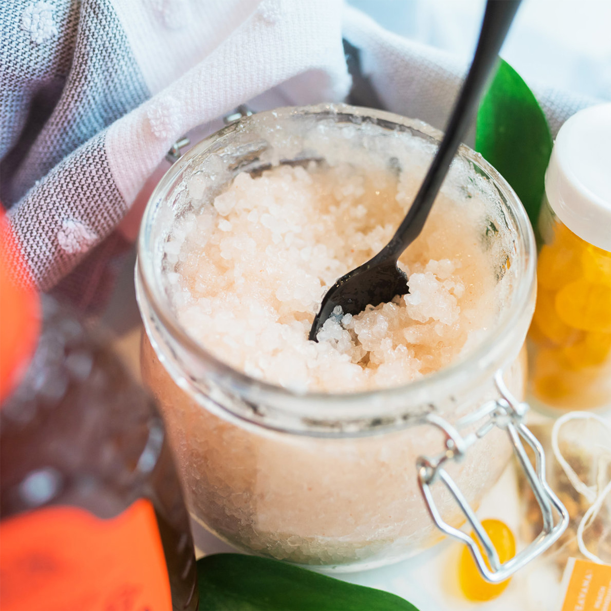 Jar of a natural honey‑based scrub with a spoon.