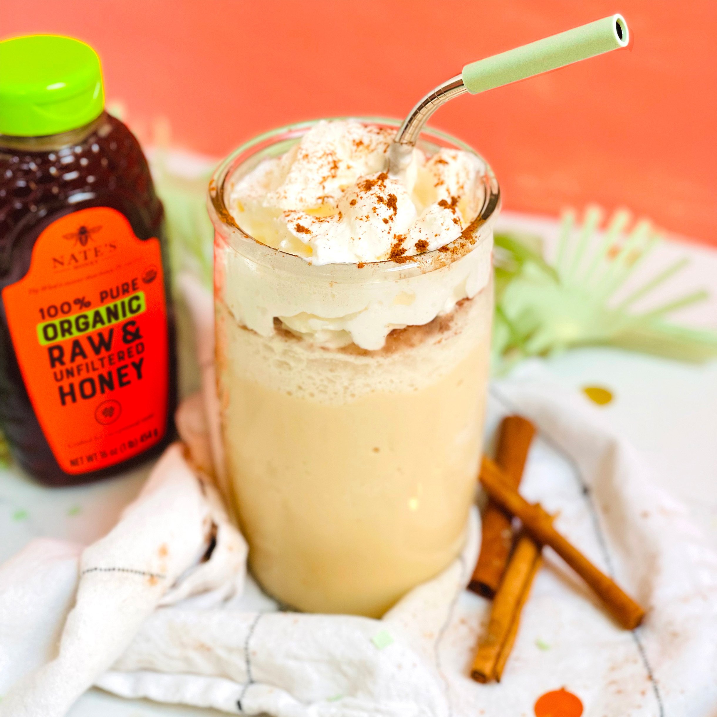 glass with snickerdoodle frappe with bottle of Nate's Organic honey in background.