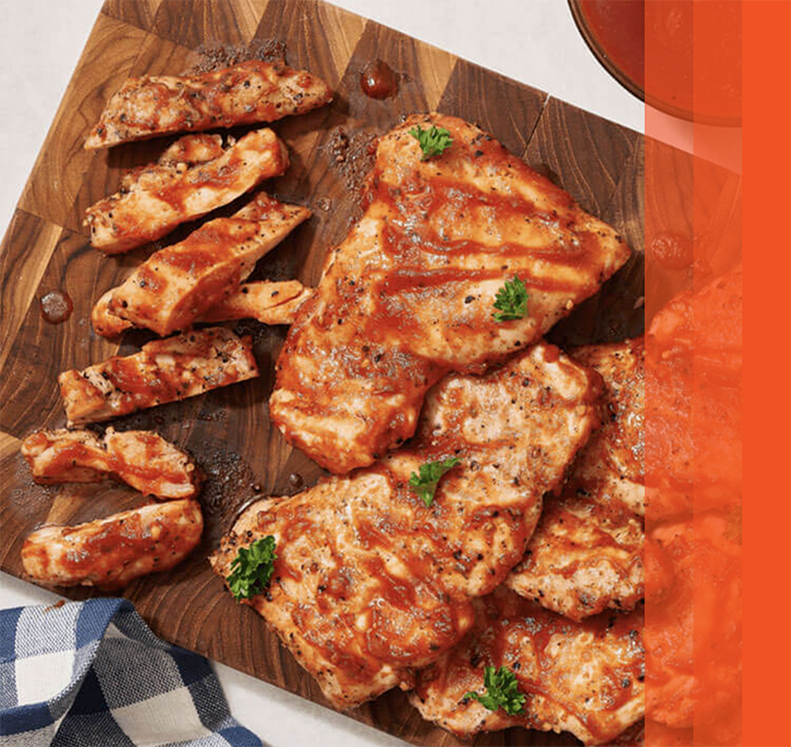 Grilled chicken with hot honey bbq sauce on wooden platter