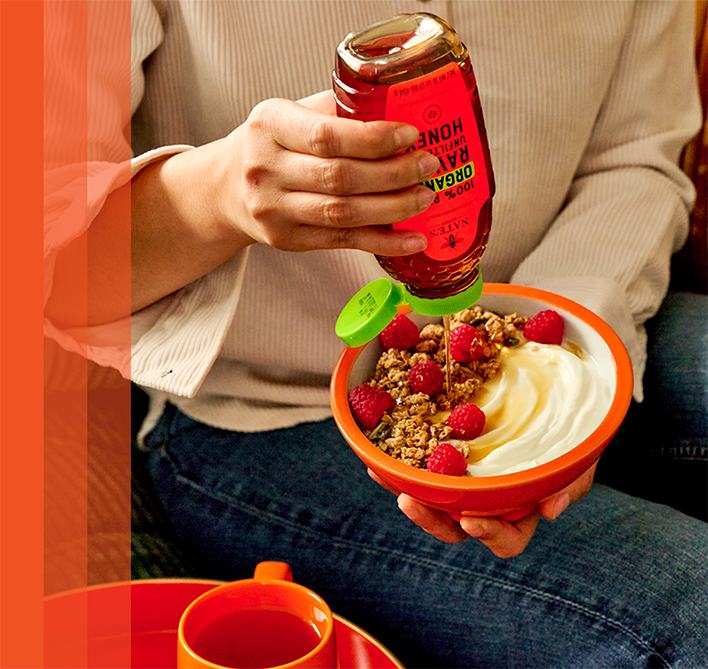 Drizzling Nate’s Organic Raw & Unfiltered Honey over yogurt topped with granola and fresh berries.