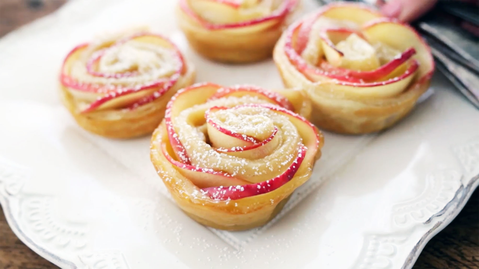sliced apple formed into flower shapes on white decorative plate