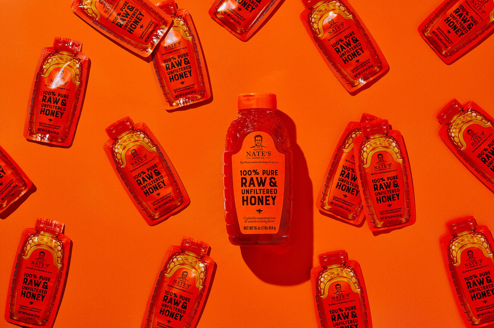 Bottle of Nate's Raw & Unfiltered Honey on an orange background.