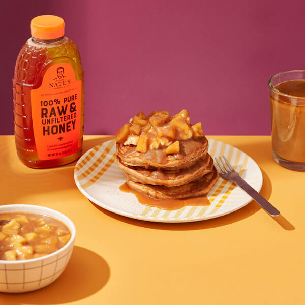 Nature Nate's Raw & Organic Honey bottle next to a plate of waffles