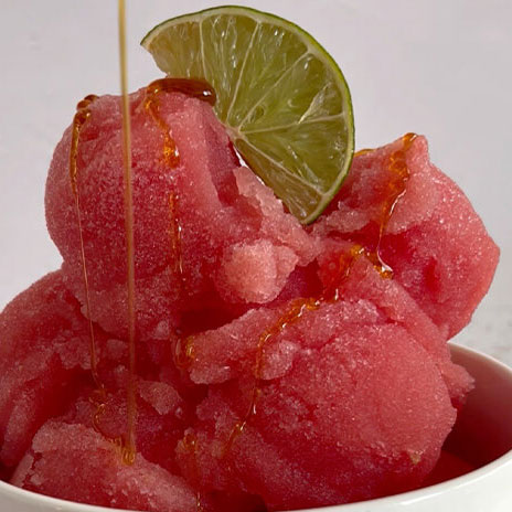 honey drizzled on watermelon lime sorbet with lime wedge