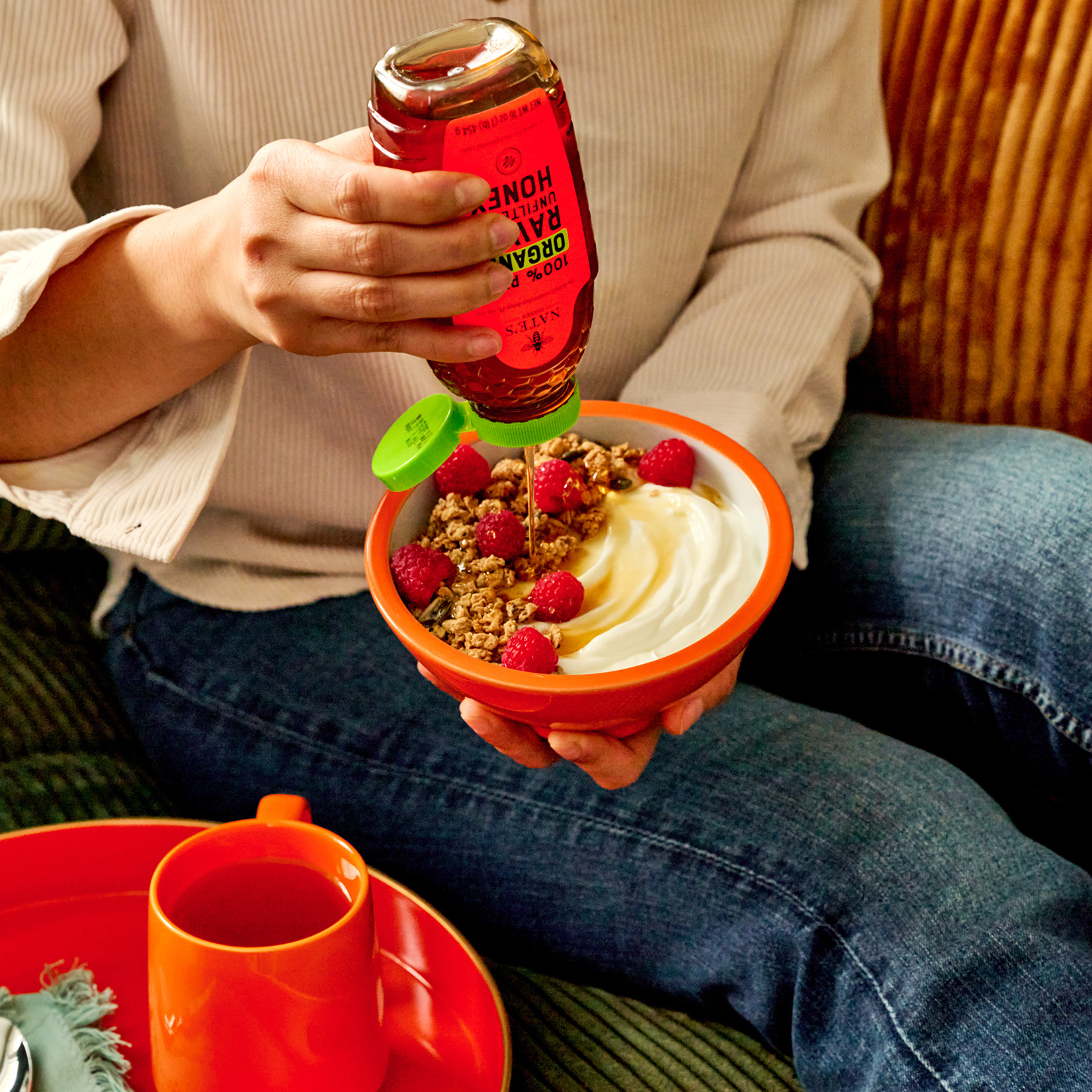 Drizzling Nate’s Organic Raw & Unfiltered Honey over yogurt topped with granola and fresh berries.